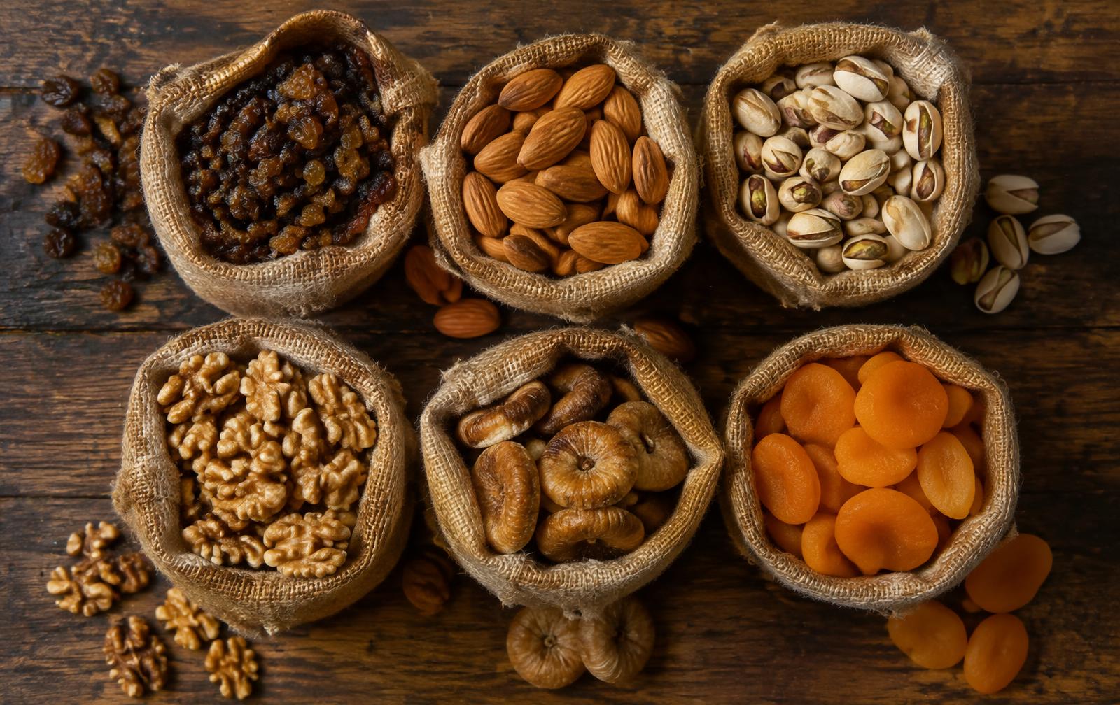 Raisins, almonds, pistachios, walnuts, figs and apricots in burlap sacks